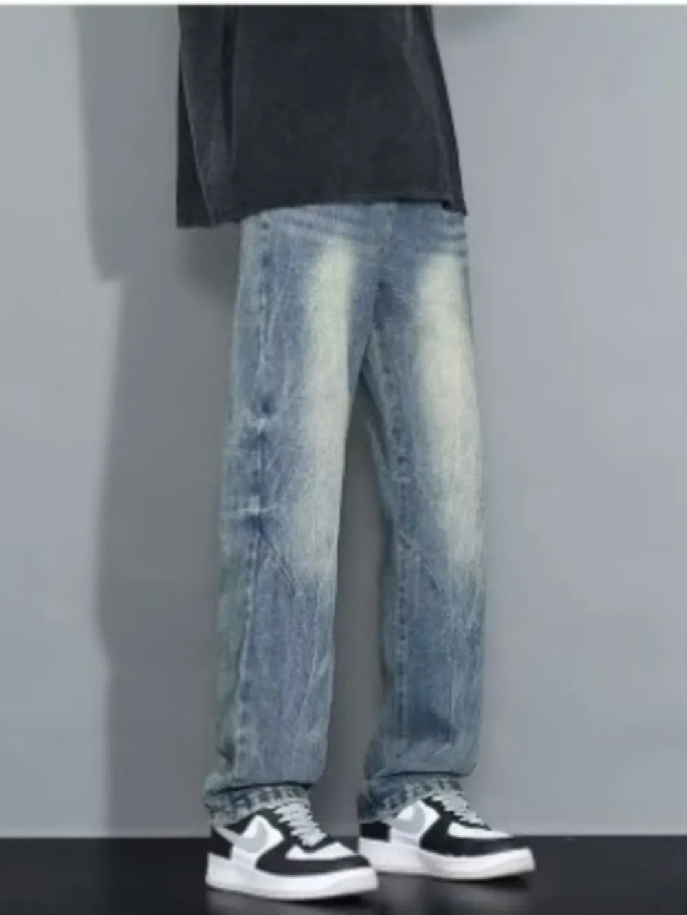 Men's loose-fit jeans in blue wash with distressed details.