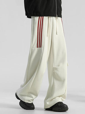 Men's cream loose-fit sweatpants with red side stripes and drawstring.
