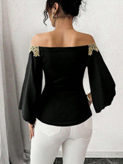 Black off-shoulder blouse with bell sleeves and gold lace trim.