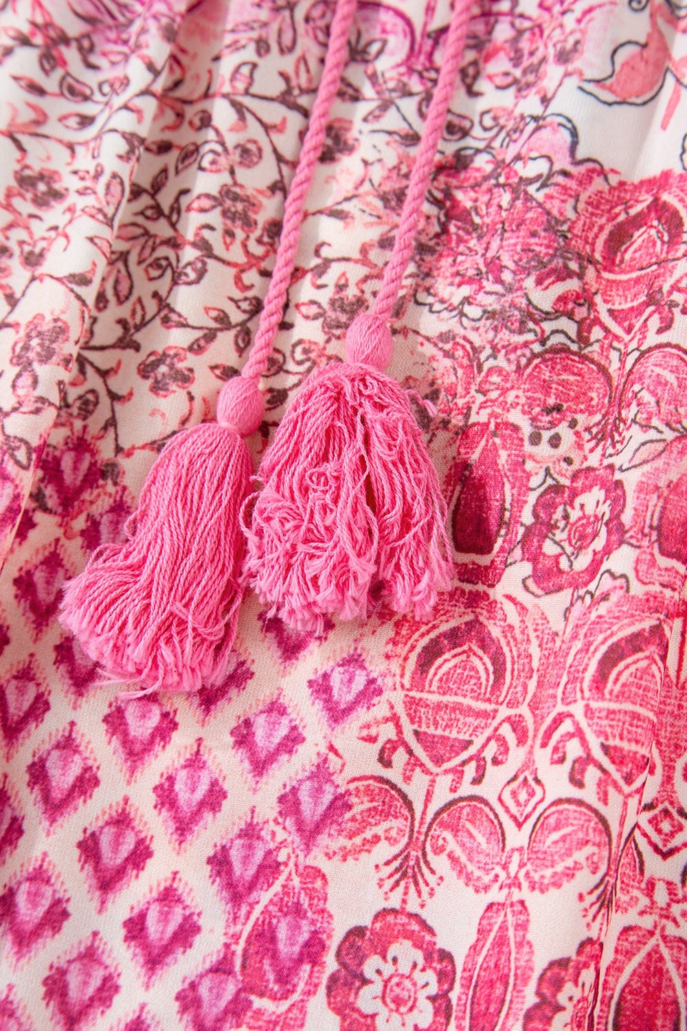 Printed tiered maxi skirt in dusty pink with tassel detail and boho floral pattern.