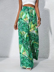 Green tropical leaf print palazzo trousers in 100% polyester with a wide leg