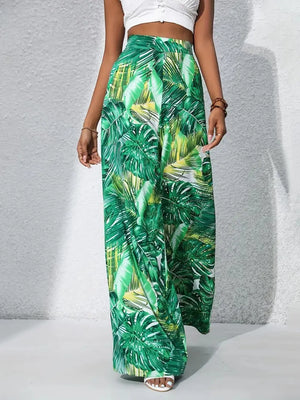 Green tropical leaf print palazzo trousers in 100% polyester with a wide leg