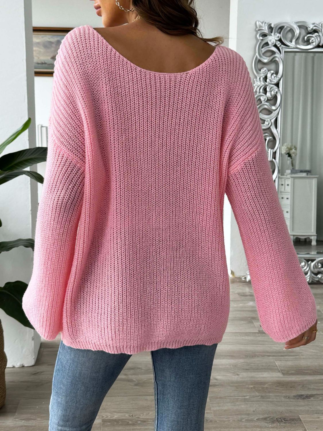 Dusty pink slouchy knit sweater with a wide neckline and bell sleeves.