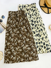 Botanical print midi skirts in black and tan with crinkled fabric and elastic waistbands.