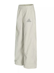 Men's light gray wide-leg sweatpants with crinkled texture and logo detail.