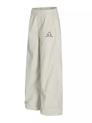 Men's light gray wide-leg sweatpants with crinkled texture and logo detail.