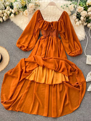 Orange ruffled square neck maternity dress with balloon sleeves and tiered skirt.