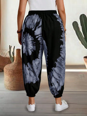 Tie-dye harem trousers with elastic waist in black and grey, featuring a relaxed fit and cuffed ankles.