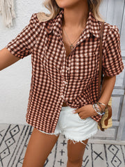 Gingham button-up short-sleeve shirt in rust red with a collared neckline and pocket.