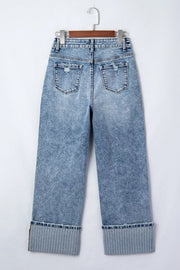 Maternity jeans in light wash denim with distressed details and striped cuffs.