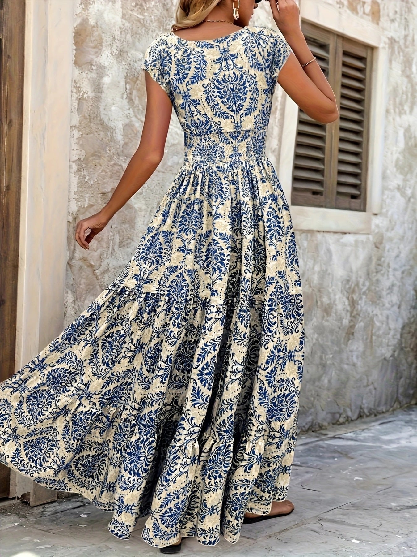 Blue damask print maxi dress with cap sleeves and tiered skirt.