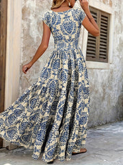 Blue damask print maxi dress with cap sleeves and tiered skirt.