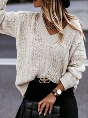 Ivory cable knit v-neck relaxed fit sweater with textured pattern.
