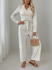 Beige vertical stripe button-down jumpsuit with tie waist and wide legs.