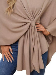 Tan knit cape top with a knotted tie-front and draped elegance.