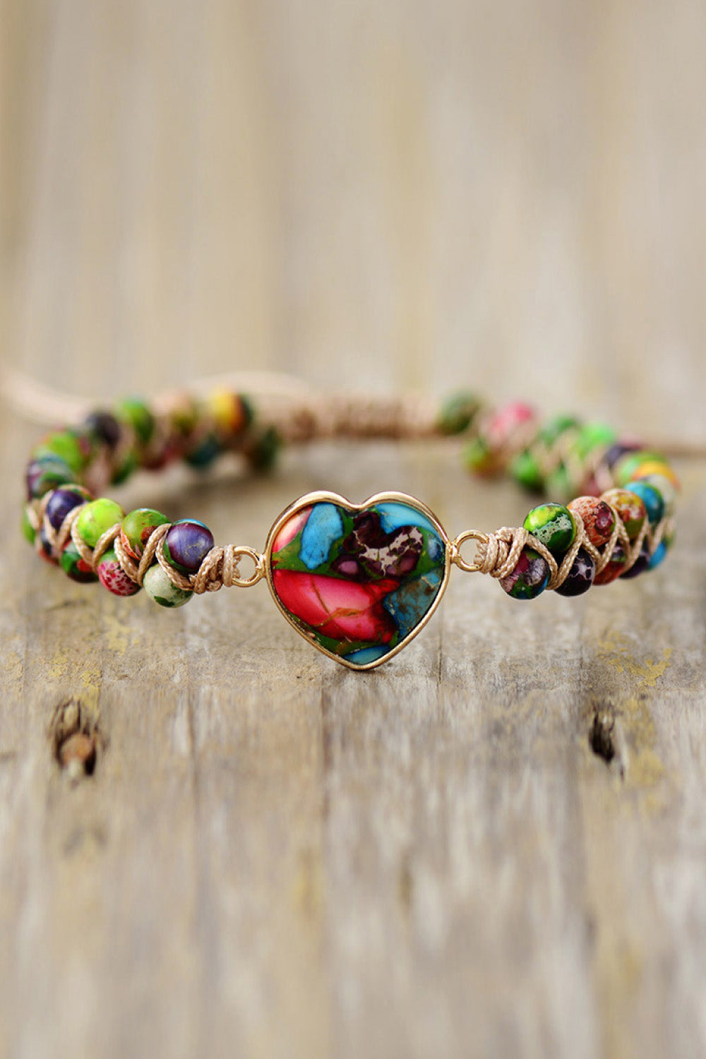 Multicolor beaded bracelet with a heart-shaped stone centerpiece and gold-tone setting.