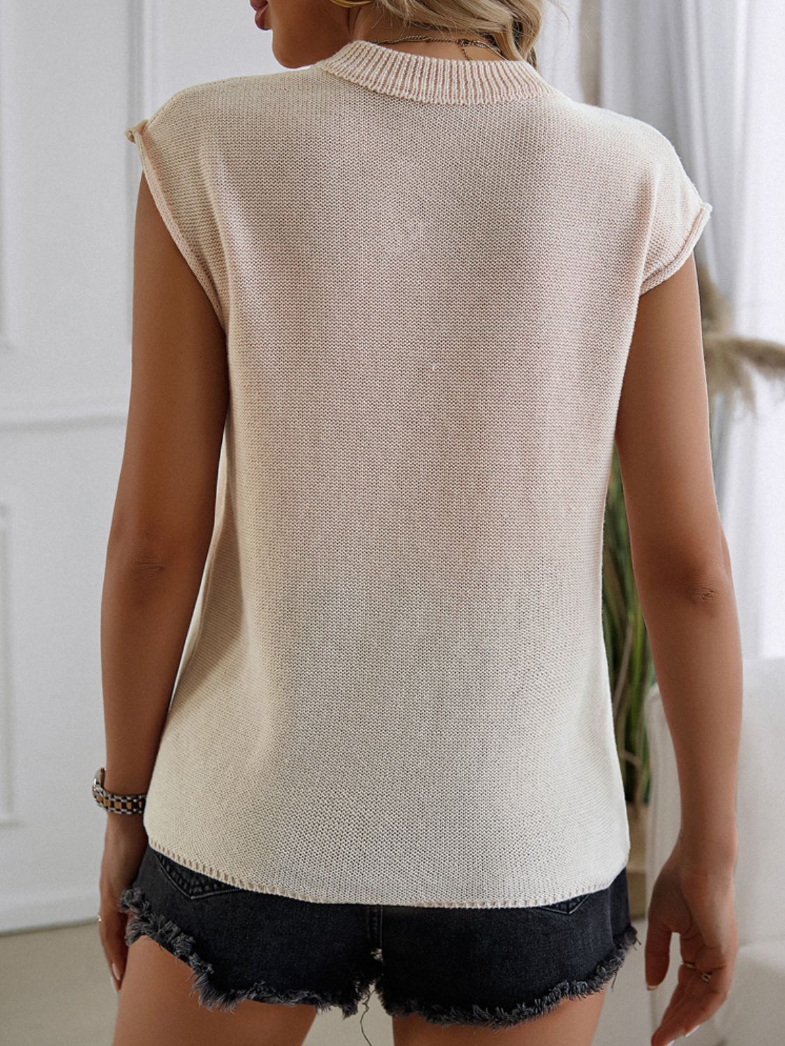 Beige knit vest with mock neckline and cap sleeves, casual basic style.