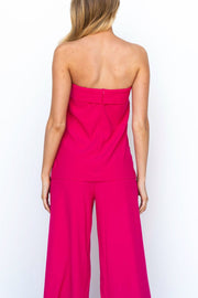 Hot pink structured bandeau top and wide-leg pants suit from the back.