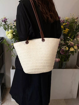 Natural straw woven large shoulder bag in beige with brown leather straps.