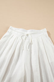 White pleated linen palazzo trousers with drawstring waist
