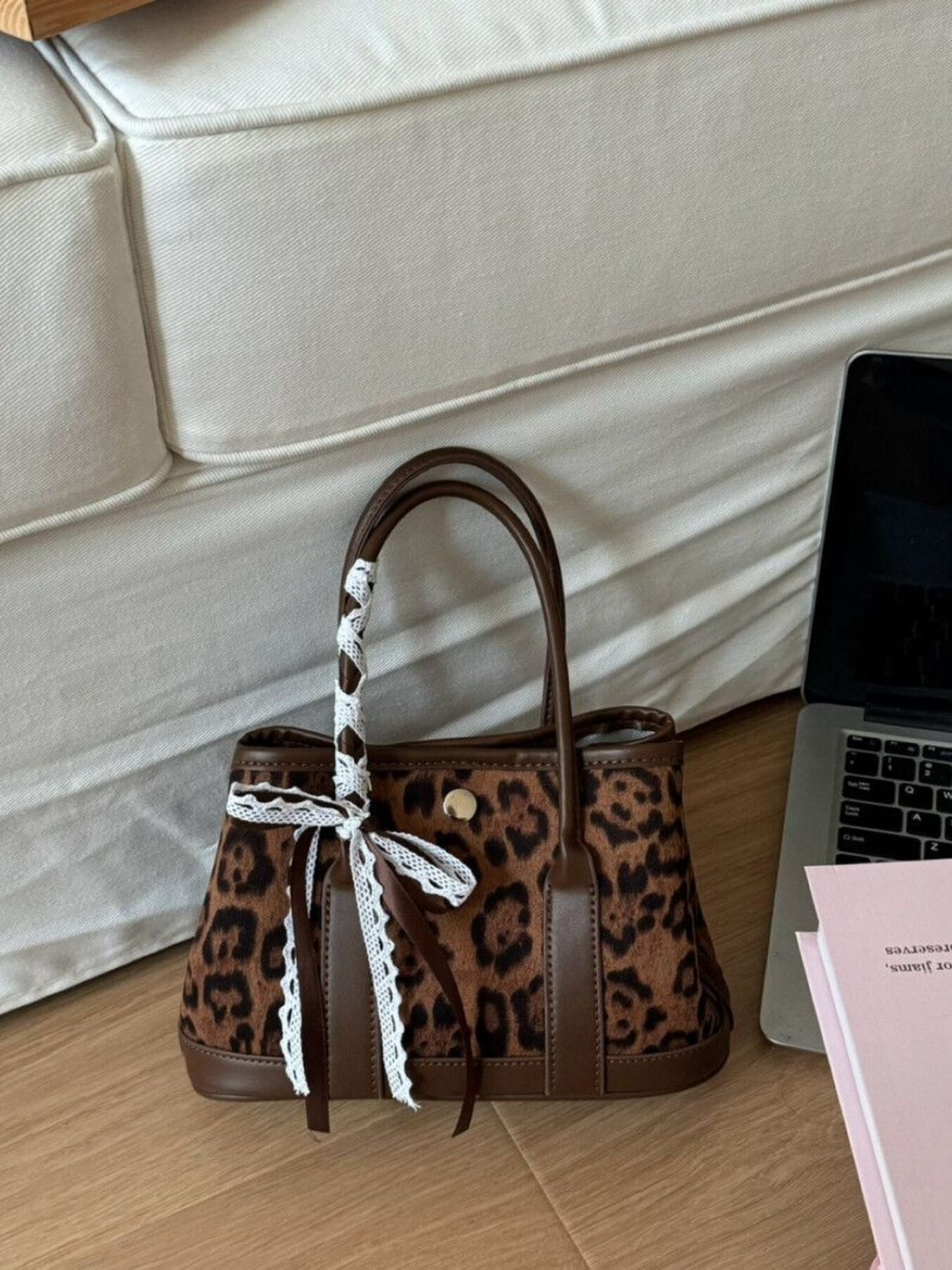 Leopard print tote bag with brown trim and lace-trimmed ribbon detail