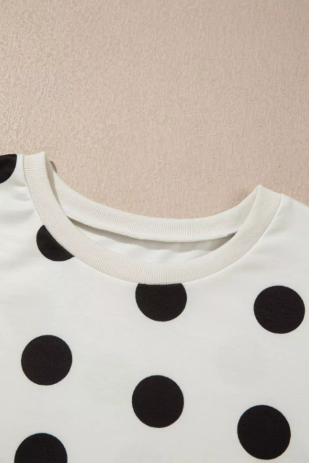 White polka dot loungewear set with crew neck top and bloused waist pants.