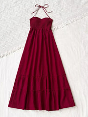 Burgundy halter neck maxi dress with smocked bodice and tiered skirt.