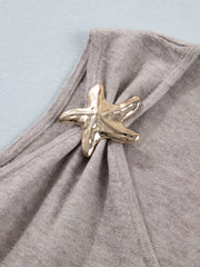 Grey V-neck knit vest with a gold starfish embellishment and draped detail.