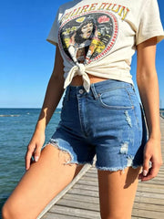 Distressed raw hem denim shorts in dark blue with button fly and frayed edges.