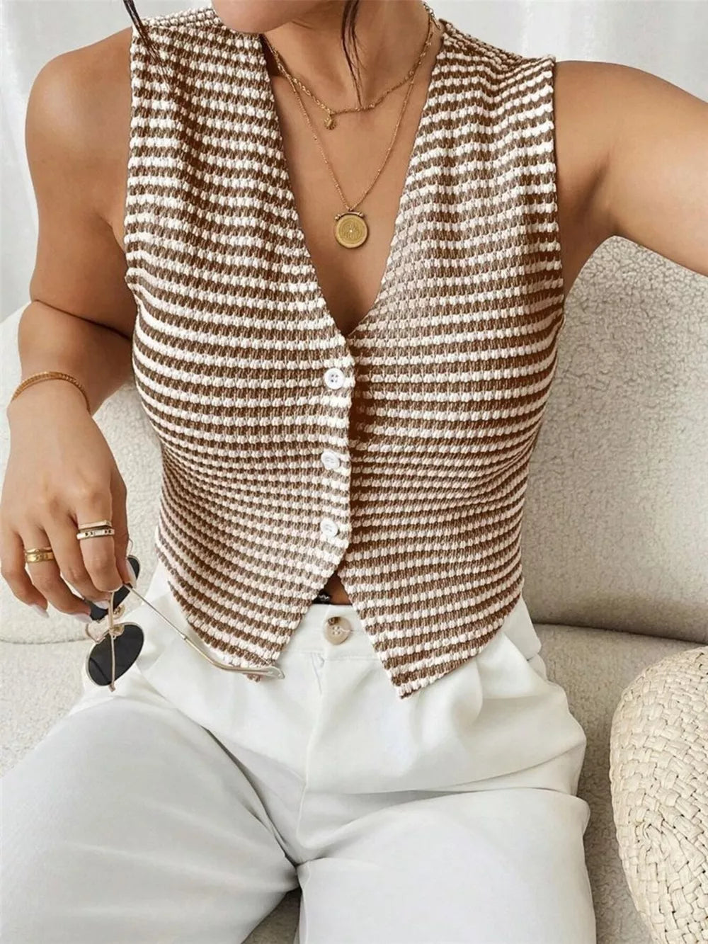 Chic striped knit v-neck tank top with button front, styled with white pants.