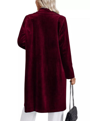 Burgundy velvet longline trench coat with lapel collar and buttoned front.