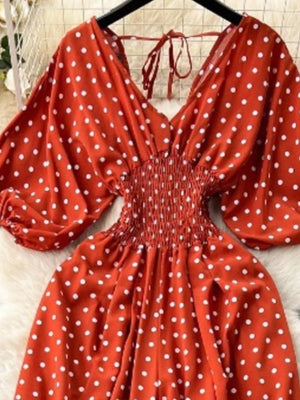 Scarlet polka dot smocked romper with tie back and wide legs.