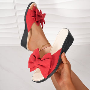 Red bow wedge sandals with comfortable slip-on style.