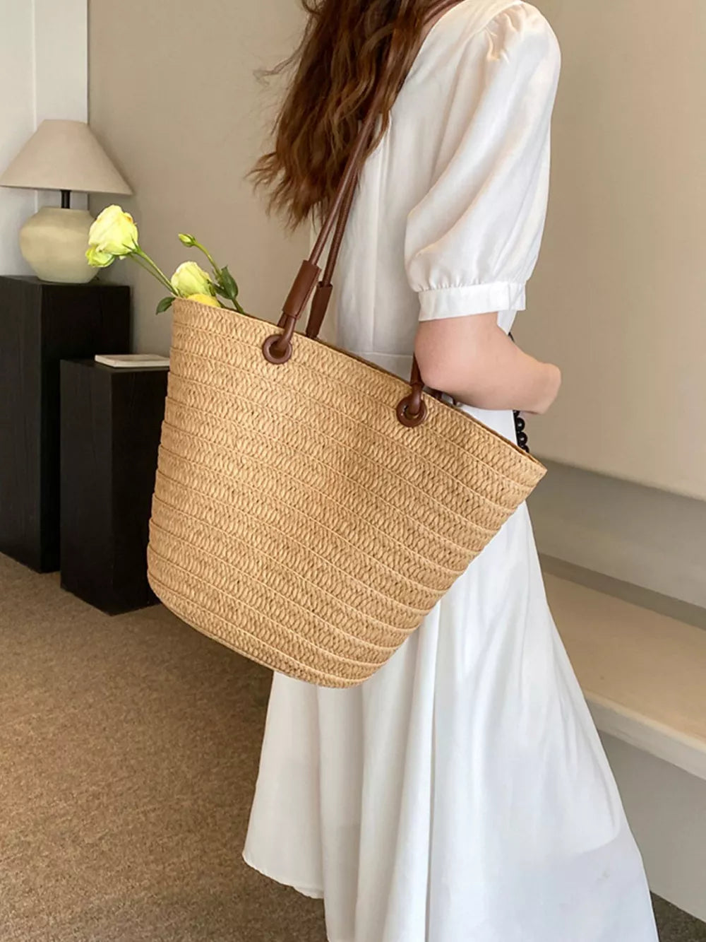 Natural straw woven large shoulder bag in khaki with leather straps, perfect for beach days.