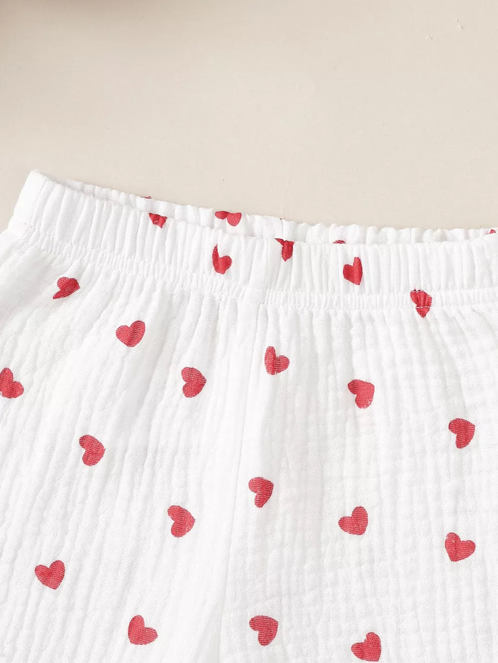 White cotton baby set with red heart print and elastic waistband detail.