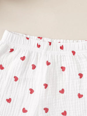 White cotton baby set with red heart print and elastic waistband detail.
