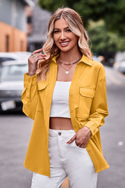 Oversized utility shirt in tangerine with button front, chest pockets, and cuffed sleeves.