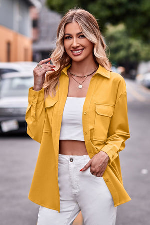 Oversized utility shirt in tangerine with button front, chest pockets, and cuffed sleeves.