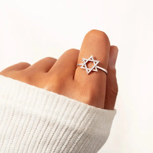 Star of David ring with white zirconia accents on a hand wearing a white sweater.