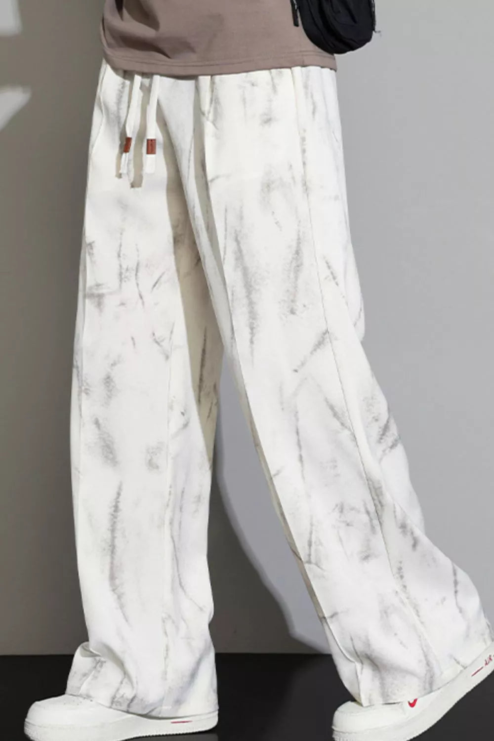 Men's white marbled drawstring sweatpants with a relaxed fit.