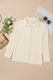 Beige pleated texture oversized button-down shirt with long sleeves.