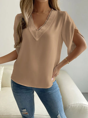 Beige polyester blouse with lace V-neck trim and cape sleeves.