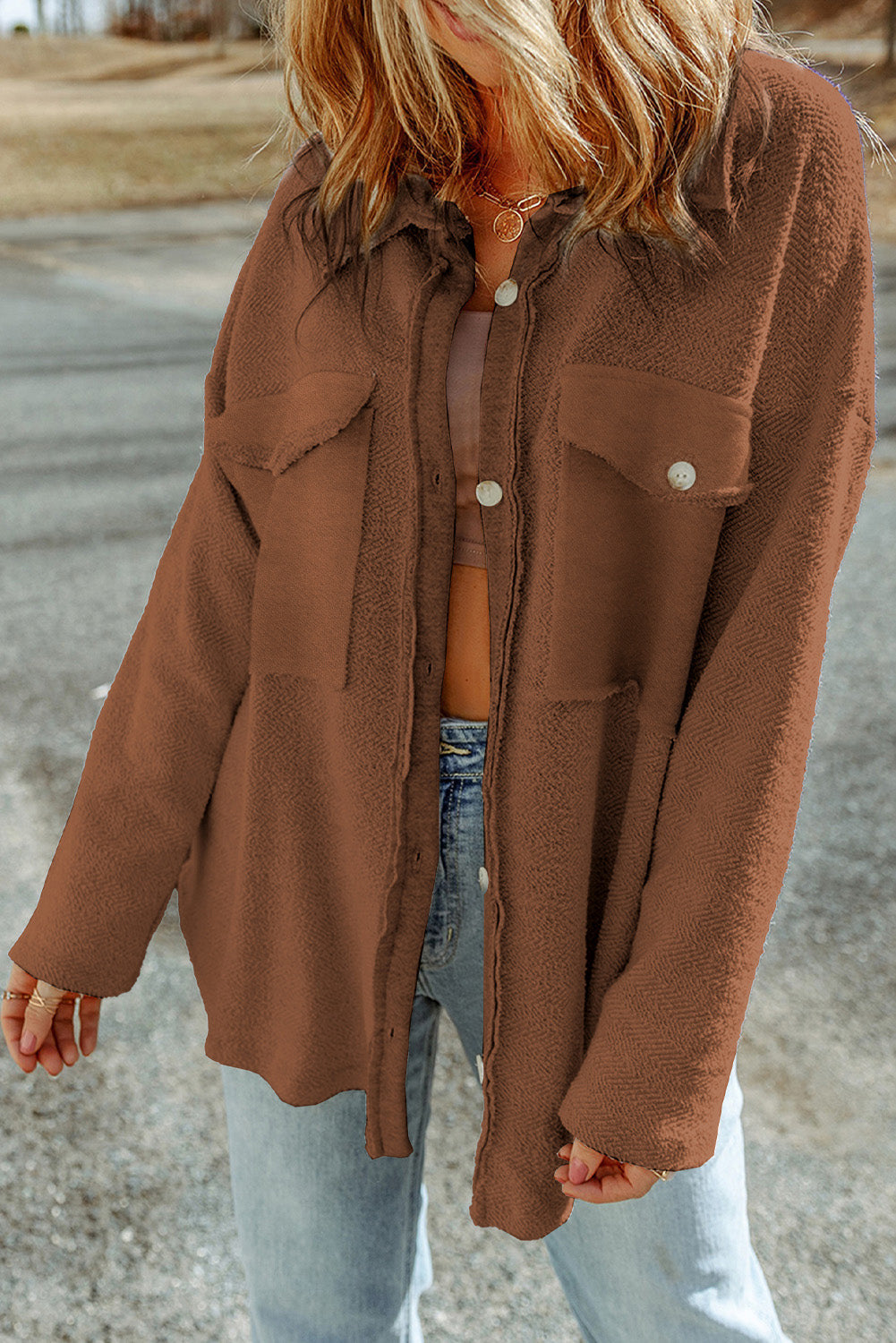 Brown textured shacket with raw edge detailing and button pockets.
