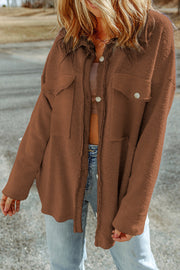 Brown textured shacket with raw edge detailing and button pockets.