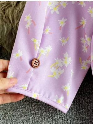 Violet floral v-neck midi dress with button detail and belted waist.