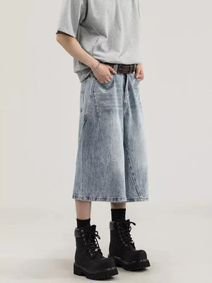 Light wash denim relaxed fit wide-leg capris with a distressed look, styled with a brown belt and black boots.