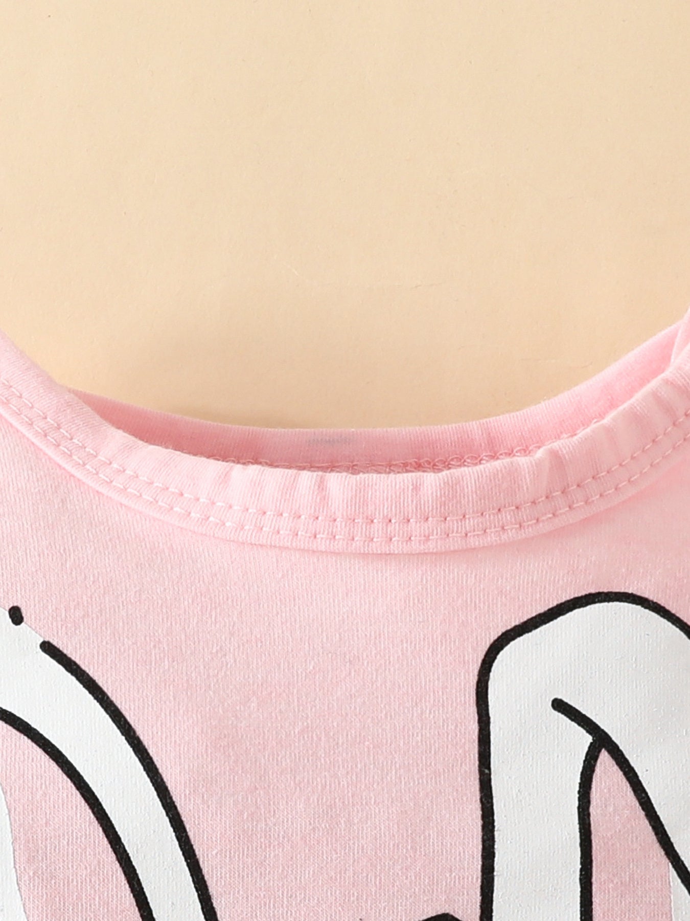 Pink baby bodysuit with bunny graphic detail and ribbed neckline.