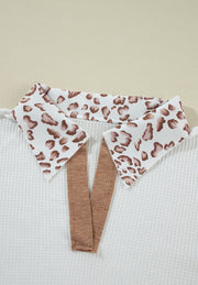 White waffle knit polo with leopard print collar detail and brown trim