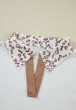 White waffle knit polo with leopard print collar detail and brown trim