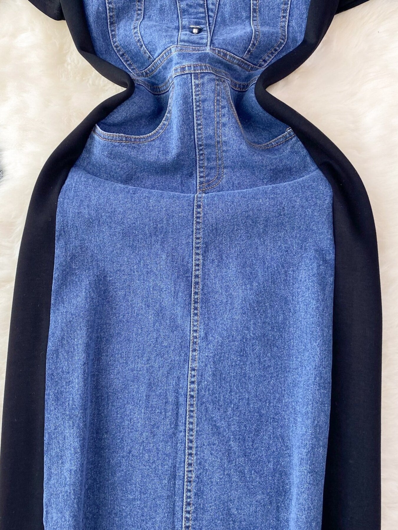 Denim patchwork short-sleeve dress in dark blue with button-down front and black side panels.